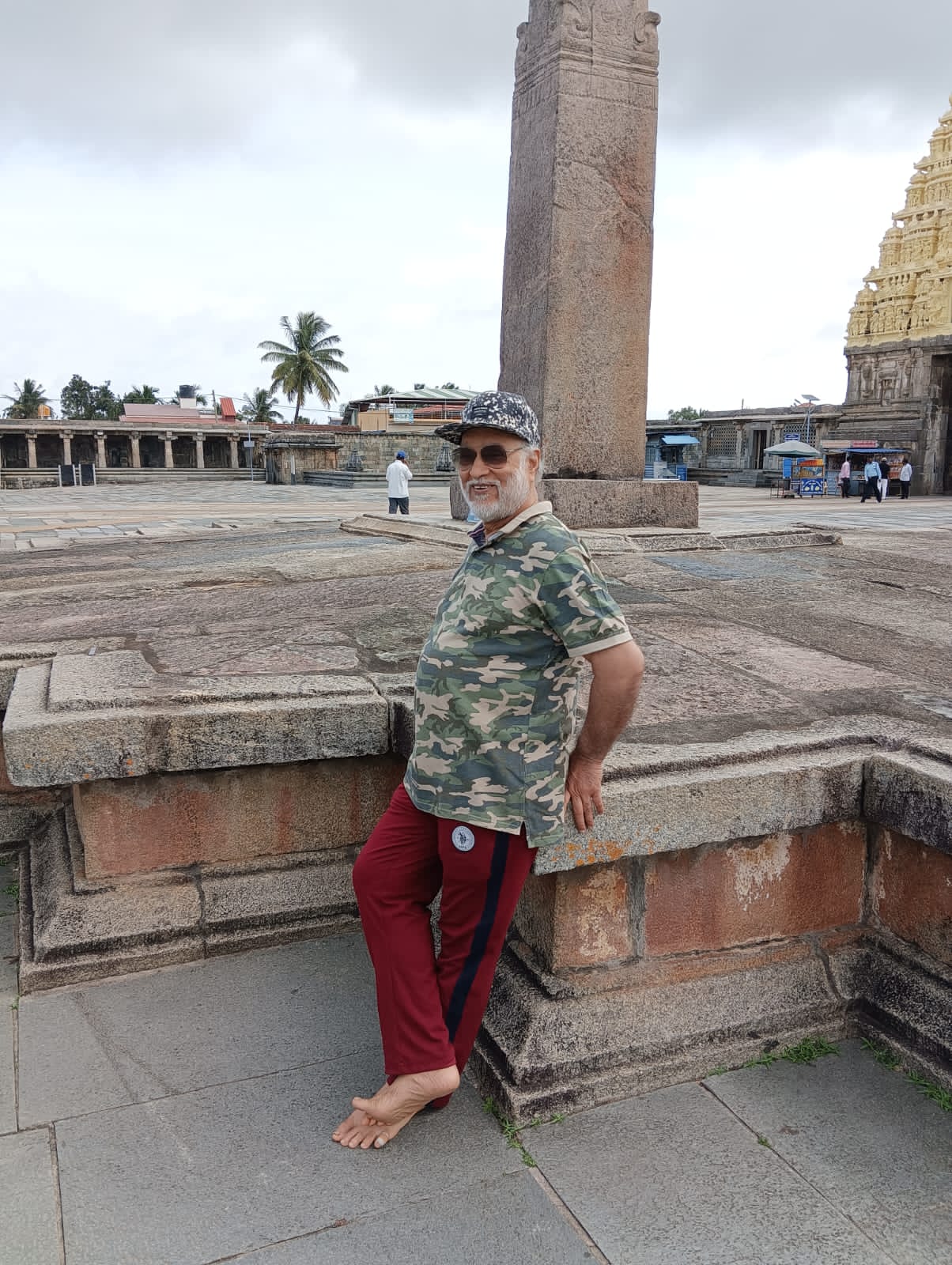Vipin Bhardwaj resting against a stone plinth in a temple courtyard