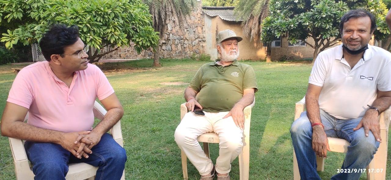 Vipin Bhardwaj seated in discussion with two colleagues on a lawn
