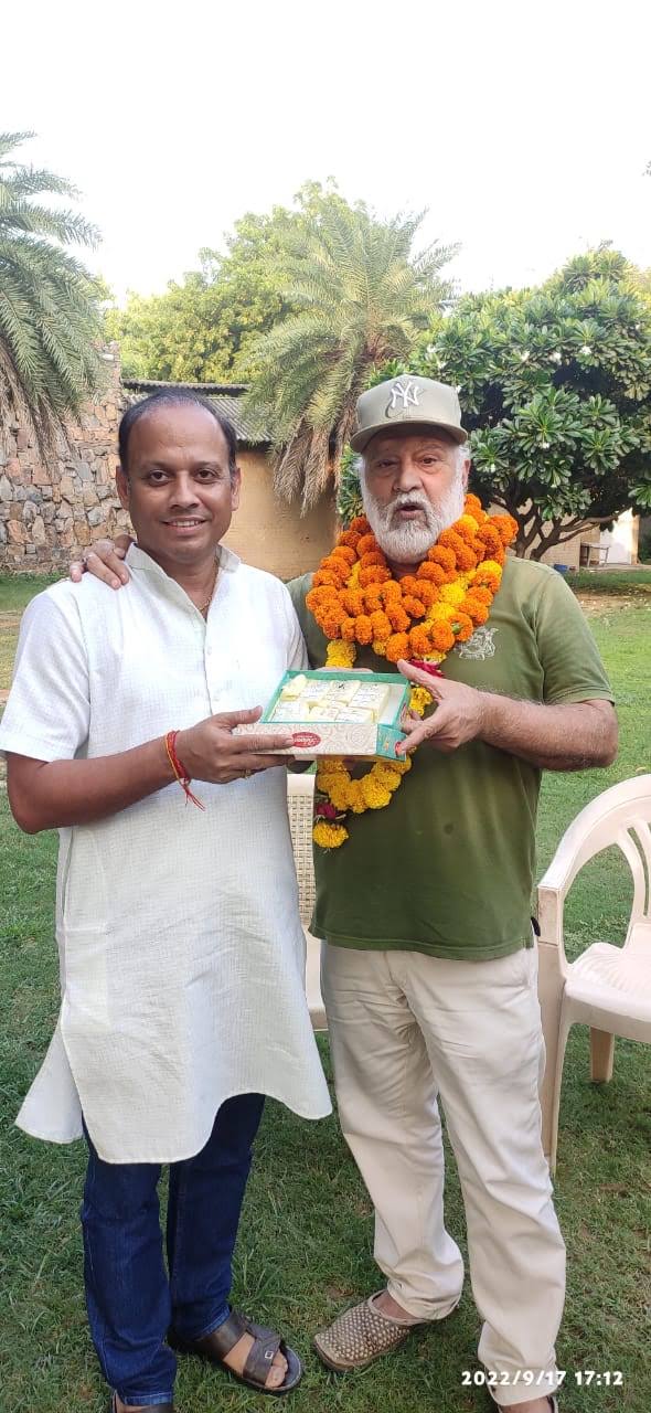 Vipin Bhardwaj garlanded and presented with a box of sweets by a colleague